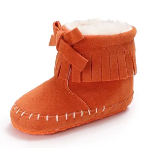 Close-up detail of an orange suede fringe baby bootie featuring soft white faux fur lining