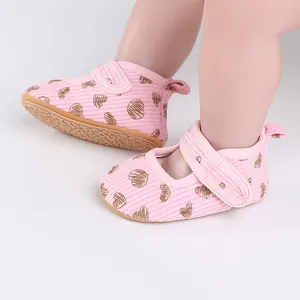 Detailed view of pink heart-patterned baby walking shoes with adjustable velcro strap