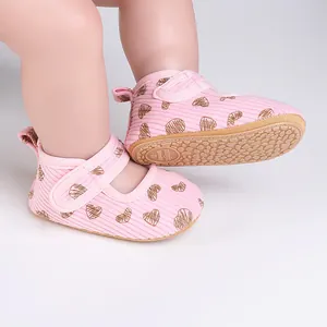 Close-up of pink baby pre-walker shoes with heart pattern and anti-slip sole