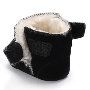 Detailweergave van de warme witte pluche voering in zwarte nubuckleren babyboots met zachte zool