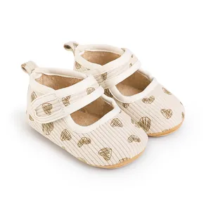 Soft-sole baby walking shoes with brown heart print on cream ribbed fabric