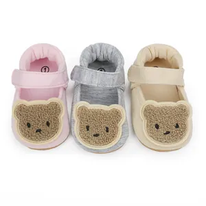 Nahaufnahme von weichen Baby-Lauflernschuhen mit süßen Bären-Patches in drei Farben