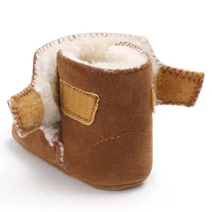 Detail van bruine suède babylaarsjes met warme voering van imitatiebont en klittenband