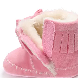 Close-up of pink infant fringe boot with warm white faux fur lining and velcro strap