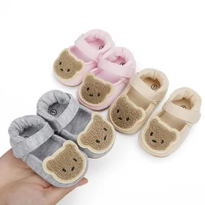 Detail von weichen Baby-Lernlaufschuhen mit süßem Plüschbär-Aufnäher