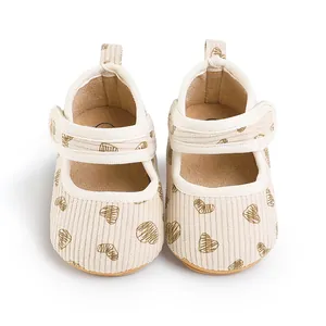 Detail view of cream corduroy baby walking shoes featuring a brown heart pattern