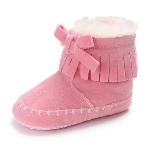Close-up of pink fringed baby boots with soft sole and white plush lining