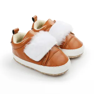 Close-up of brown baby walking shoes with white faux fur detail and soft soles.