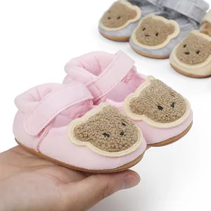 Detailed view of soft pink baby walker shoes featuring a cute plush cartoon bear design.