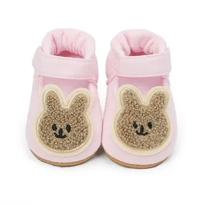 Primer plano de zapatos rosas para bebés con un lindo diseño de conejo bordado