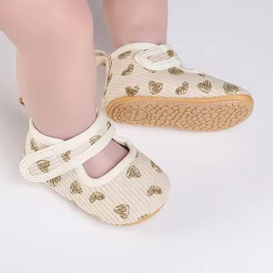 Close-up of baby walking shoes featuring heart patterns and anti-slip rubber soles