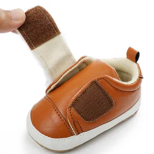 Detail view of brown baby walking shoe showing adjustable Velcro strap and plush interior lining
