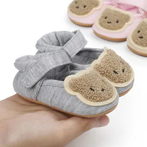 Macro detail view of a soft gray baby walker shoe featuring a cute plush teddy bear toe