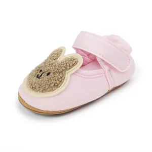 Detalle de zapato de bebé rosa para primeros pasos con parche de conejito marrón suave