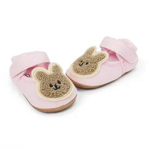 Lindos zapatos rosas para primeros pasos de bebé con un conejo de peluche para niños