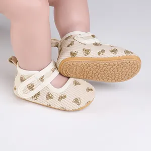 Close-up view of beige baby walking shoes featuring a heart pattern and a non-slip rubber sole