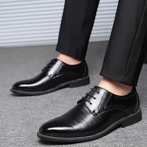 Élégantes chaussures de ville noires à bout pointu portées avec un pantalon de costume.
