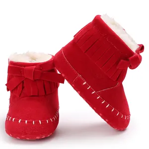 Detailed view of red toddler fringe boots featuring soft faux fur lining and a bow