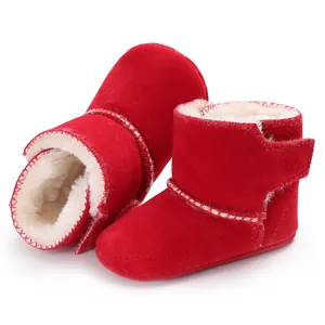 Detail van rode matte leren babylaarzen met zachte fleecevoering en klittenband