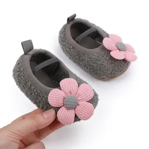 Close-up of soft grey baby shoes with large pink flower and elastic strap