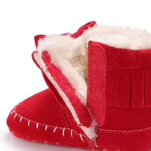 Close-up of red fringe baby boots with soft white faux fur lining and Velcro strap
