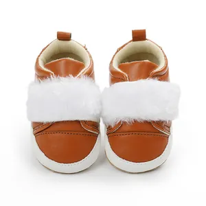 Front close-up of brown baby walking shoes with white plush fur strap decoration