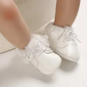 Close-up detail of white fur-lined infant boots with soft soles and white laces