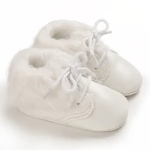 Close-up view of white infant fur boots with soft sole and warm fuzzy faux fur lining