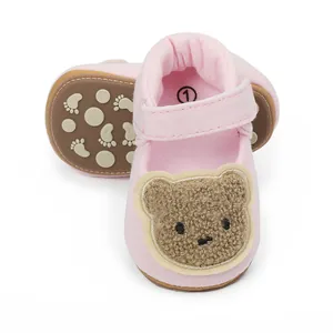 Detailed close-up of pink baby walker shoes featuring a cute cartoon bear embroidery.