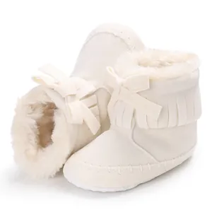 Close-up detail of cream fringe baby boots featuring soft soles and warm faux fur lining