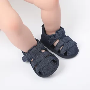 Primer plano de sandalias de bebé en denim azul oscuro con diseño de tiras transpirables