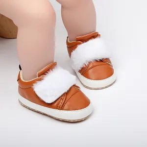 Close-up of brown baby girl princess shoes with white fur trim and soft white soles.