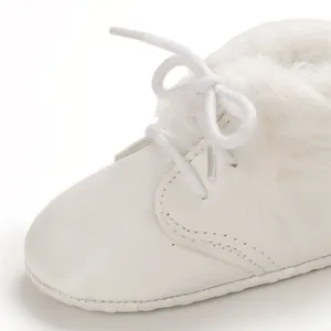Detailed close-up showing soft faux fur lining and leather texture on white baby boots
