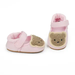 Detailed view of pink baby walker shoes with cute plush bear embroidery and Velcro strap.