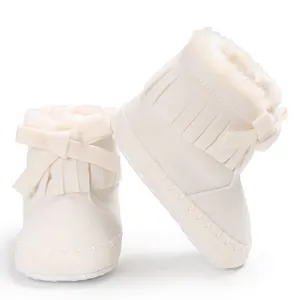 Detailed view of cream baby fringe boots with bow and faux fur lining