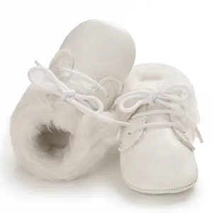 Macro view of white faux fur collar and lace-up details on baby soft sole boots