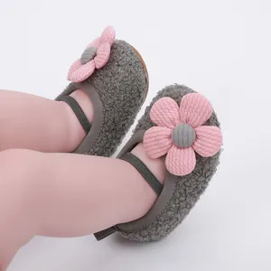 Detailed view of cozy grey sherpa infant shoes featuring large pink fabric flower accents