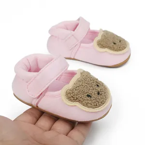 Detailansicht der rosa Baby-Lauflernschuhe mit einem süßen braunen Teddybären