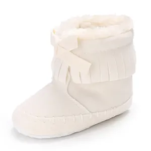 Close-up of cream white baby tassel boot featuring soft faux fur lining and cute bow detail