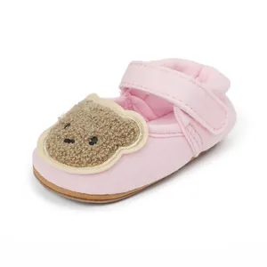 Detailansicht eines rosa Baby-Lauflernschuhs mit einem niedlichen Cartoon-Bären-Aufnäher
