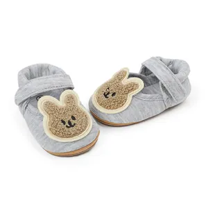 Primer plano de zapatos grises para bebés con un parche de conejo de peluche bordado