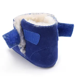 Gedetailleerd beeld van blauwe suède babyschoen met warme witte pluche voering en klittenband.