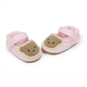 Detail view of pink baby walking shoes with cute teddy bear applique and hook-and-loop strap.