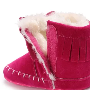 Close-up of fuchsia baby boots with tassel detail and soft faux fur lining for warmth.