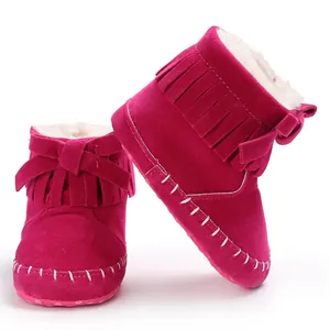 Detail of vibrant fuchsia baby fringed boots with soft fur lining and bow decoration