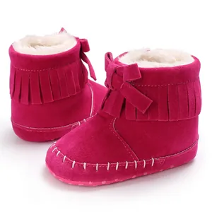 Detailed macro view of pink fringe baby boots featuring soft white fur lining and bow