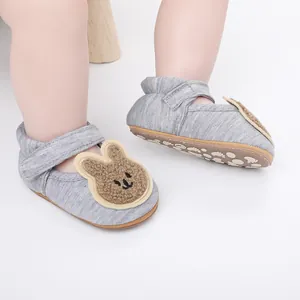 Primer plano detallado de zapatos de bebé grises con un lindo diseño de conejo
