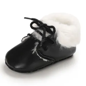 Close-up detail of cozy baby boot featuring soft white fur lining and black leather