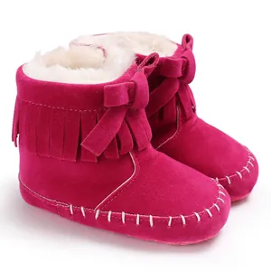 Macro detail of hot pink baby fringe boots with soft white fleece lining and bow