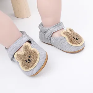 Primer plano de zapatos de bebé grises con un lindo parche de conejo de peluche bordado